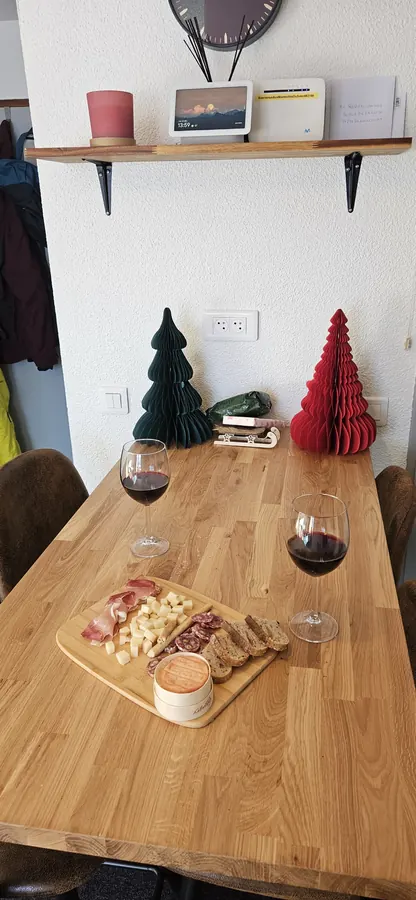 Coin repas en ambiance hivernale, plateau charcuterie-fromage sur la table en bois