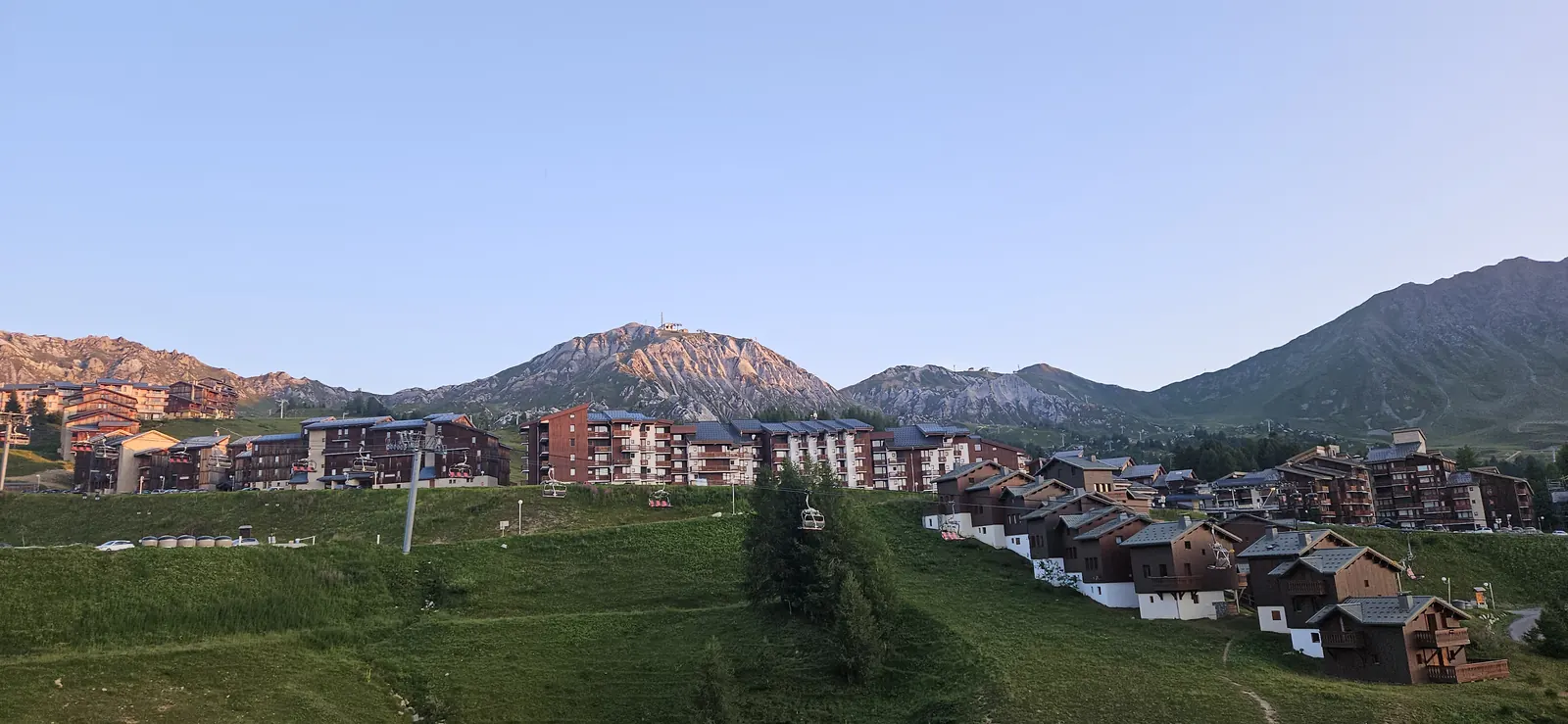 La Plagne Soleil en été, prairies vertes, chalets et vue sur les sommets rocheux de Tarentaise