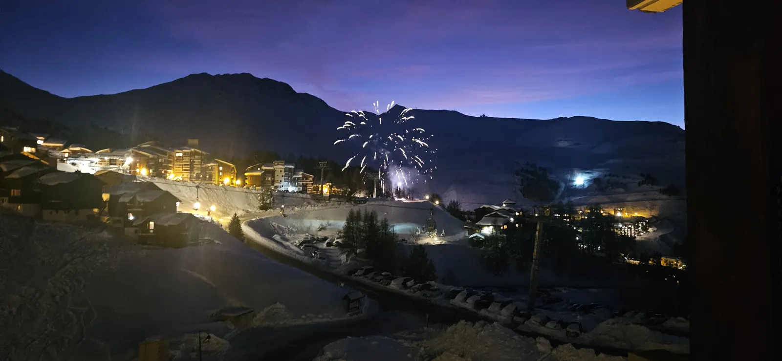 Feux d'artifice depuis le balcon, ciel violet et station illuminée de La Plagne Soleil